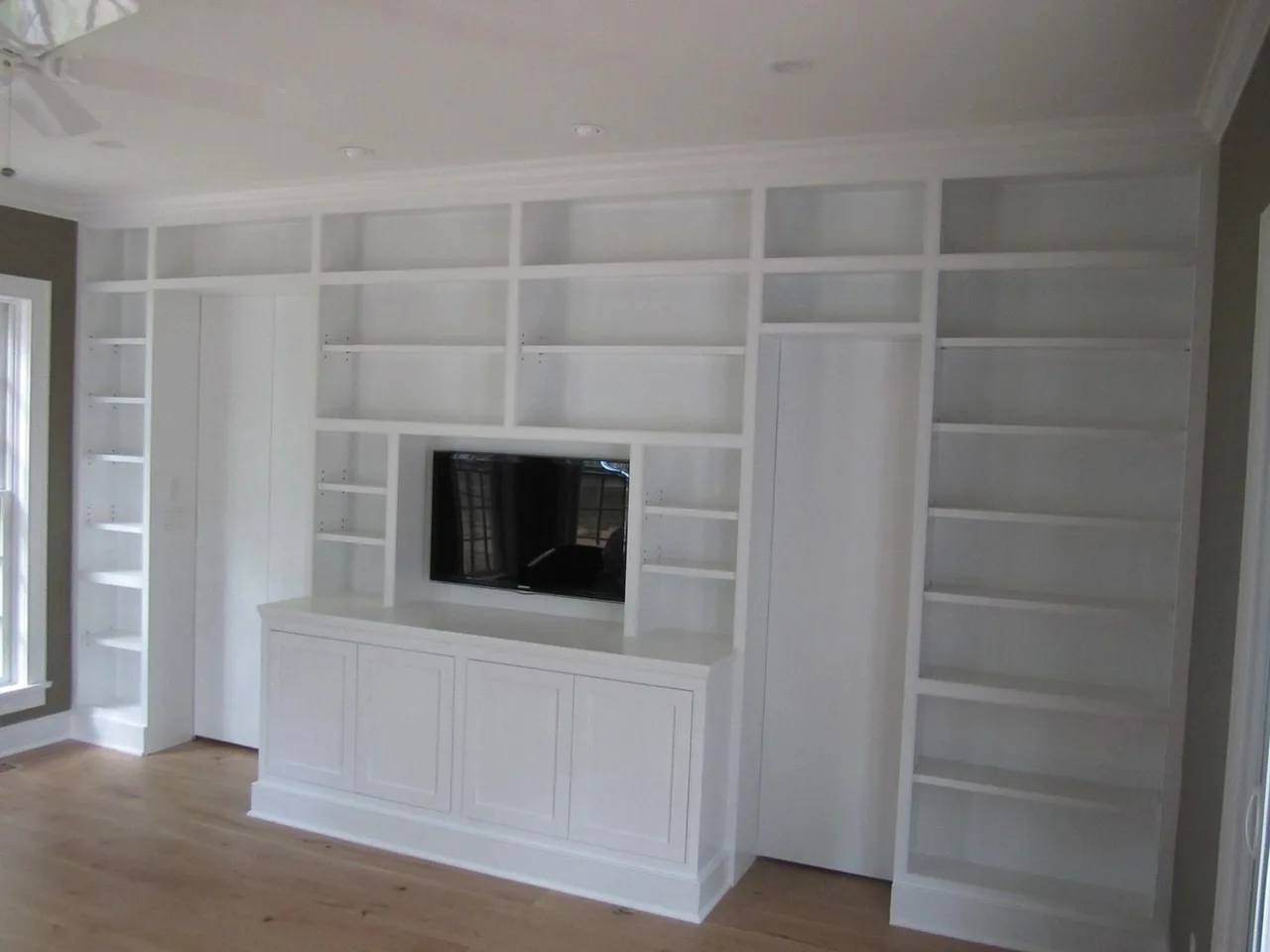 white wall of shelves with TV and base cabinets, Built-Ins & Furniture